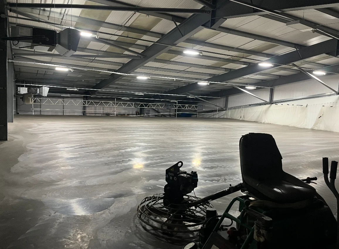 Power float machine finishing a concrete floor for a commercial garage